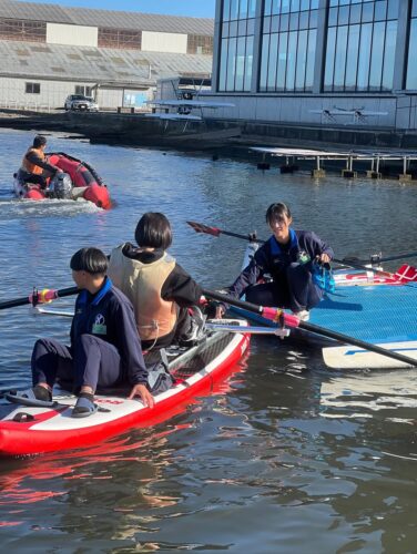 七尾高校ボート部が開催した操艇の体験会をSUPで海上から見守りました
